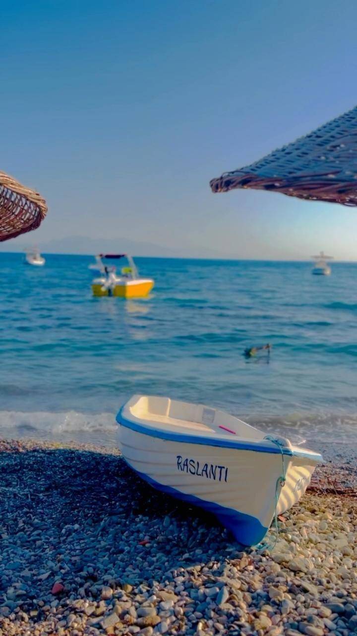 Çakıllı plajda Rastlantı yazılı sandal